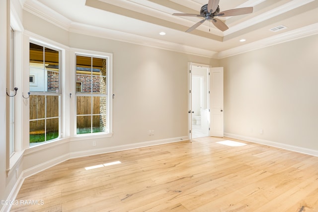 spare room with crown molding, a raised ceiling, light hardwood / wood-style flooring, and ceiling fan