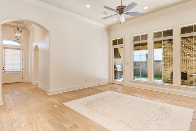 spare room featuring light hardwood / wood-style floors, a healthy amount of sunlight, and crown molding