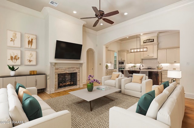 living room with light hardwood / wood-style floors, a premium fireplace, and ornamental molding