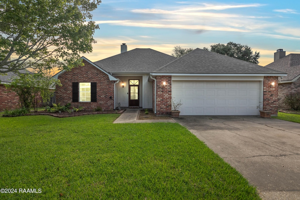 ranch-style house featuring a yard and a garage