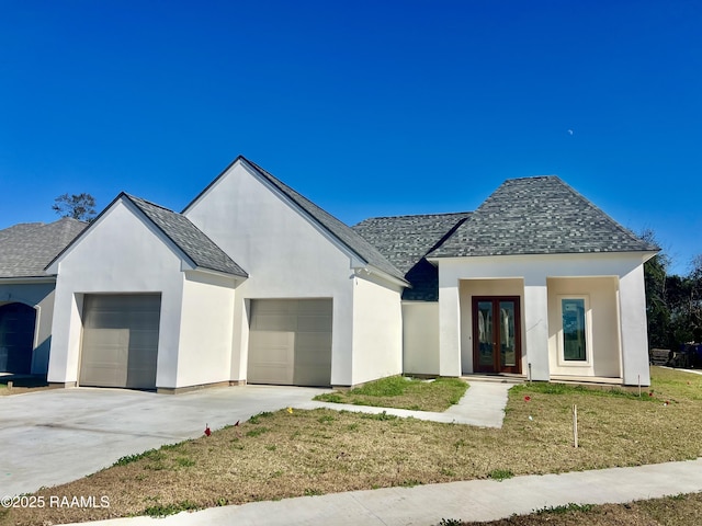 view of front of property with a garage, a front yard, and french doors