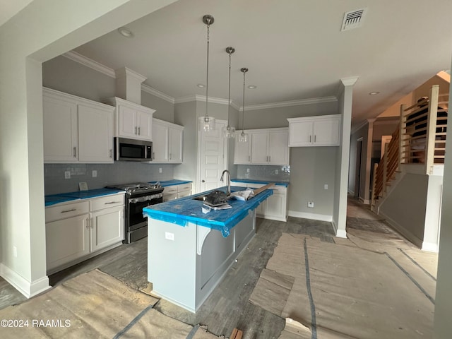 kitchen with appliances with stainless steel finishes, tasteful backsplash, a kitchen island with sink, white cabinetry, and hanging light fixtures