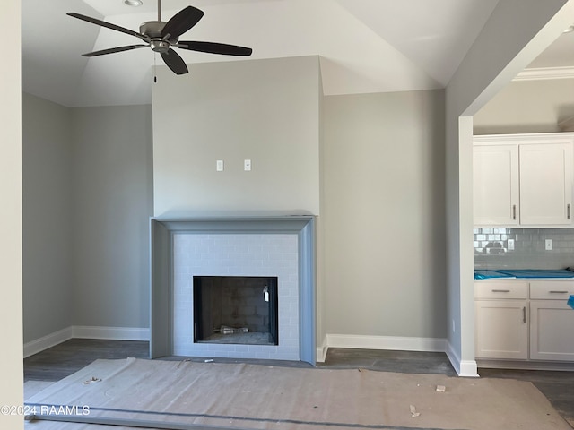 unfurnished living room with ceiling fan, dark hardwood / wood-style floors, vaulted ceiling, and a brick fireplace