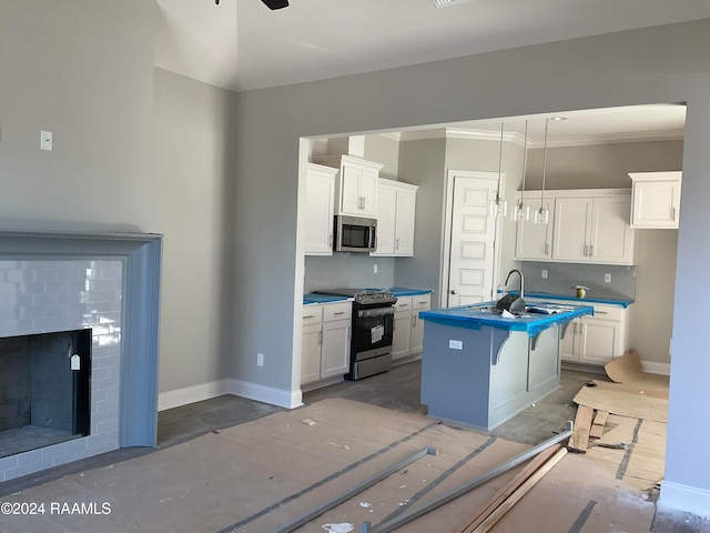 kitchen featuring backsplash, a center island with sink, white cabinets, and appliances with stainless steel finishes