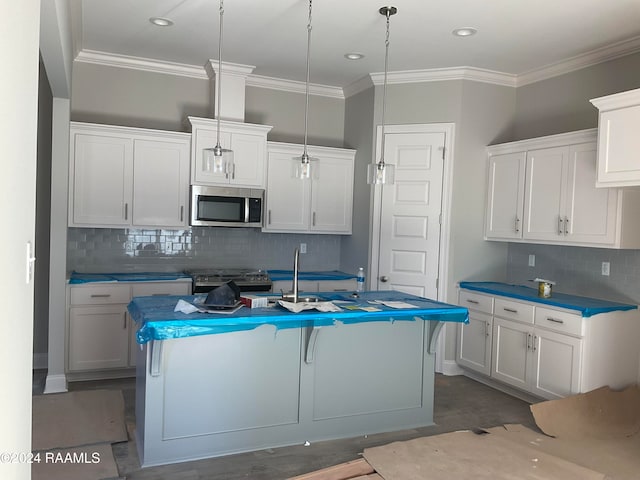 kitchen featuring white cabinets, a center island with sink, hanging light fixtures, and appliances with stainless steel finishes