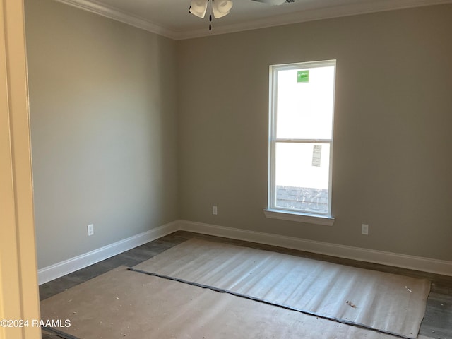 spare room with ceiling fan, ornamental molding, and dark wood-type flooring