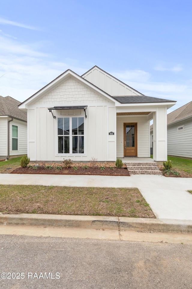 modern inspired farmhouse featuring covered porch and board and batten siding