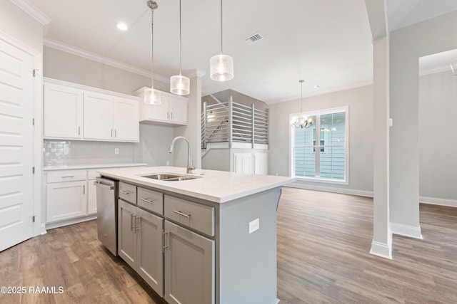 kitchen with white cabinetry, a center island with sink, decorative light fixtures, and a sink