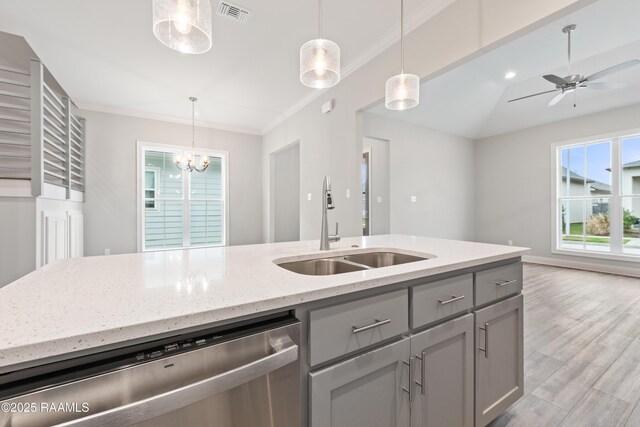 kitchen with light stone counters, a sink, visible vents, stainless steel dishwasher, and pendant lighting