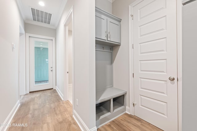 mudroom featuring light wood finished floors, baseboards, visible vents, and crown molding