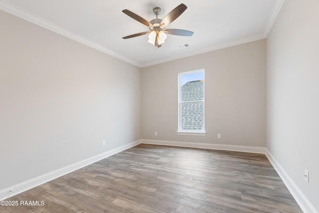 unfurnished room with baseboards, crown molding, visible vents, and wood finished floors