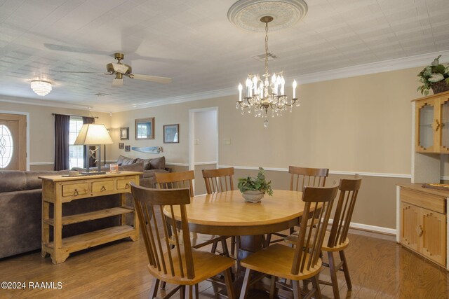 dining space featuring ceiling fan with notable chandelier, light hardwood / wood-style floors, and crown molding