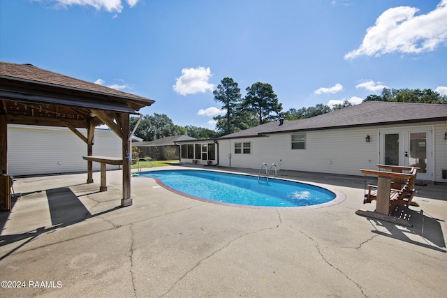 view of pool with french doors, a patio, and a gazebo