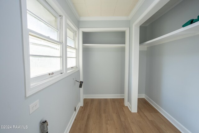 interior space with light wood-type flooring and ornamental molding