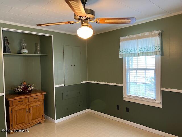 unfurnished bedroom with ceiling fan, a closet, and crown molding