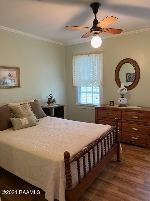 bedroom with wood-type flooring, ceiling fan, and crown molding