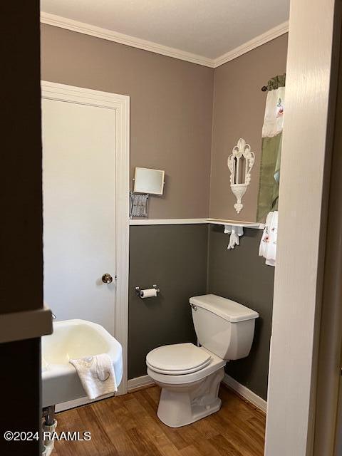 bathroom with toilet, wood-type flooring, and ornamental molding