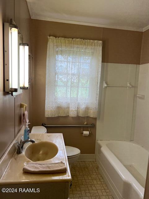 bathroom with toilet, a washtub, vanity, and crown molding