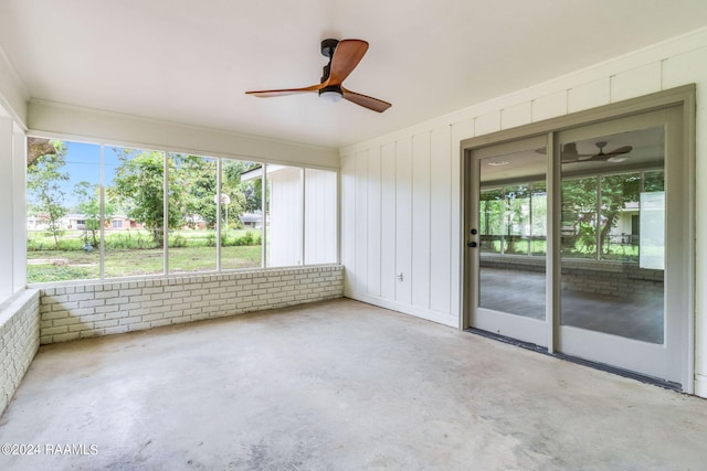 unfurnished sunroom with ceiling fan