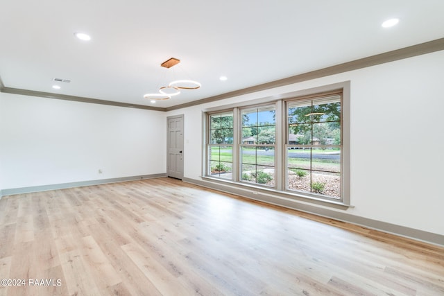 unfurnished room with a notable chandelier, light hardwood / wood-style flooring, and crown molding