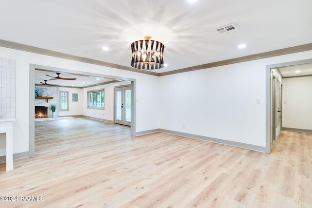 unfurnished living room with ornamental molding, light wood-type flooring, ceiling fan, and a fireplace