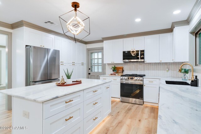 kitchen featuring white cabinetry, light stone countertops, pendant lighting, stainless steel appliances, and sink