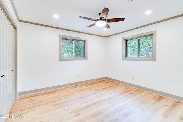 unfurnished bedroom featuring crown molding, light hardwood / wood-style floors, ceiling fan, and a closet