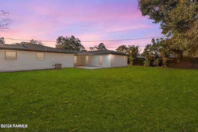 yard at dusk featuring a patio area