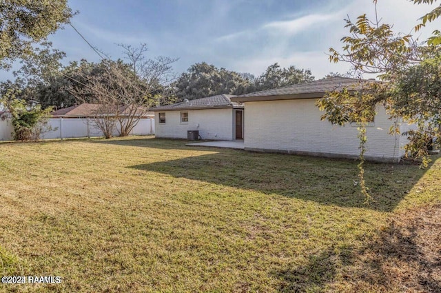 back of house featuring a lawn, a patio, and cooling unit