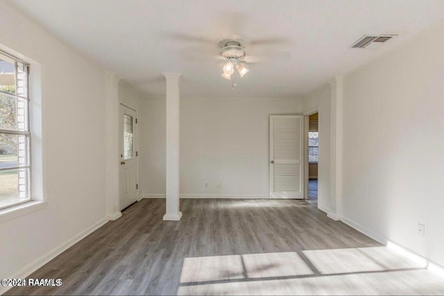 empty room with hardwood / wood-style floors, ceiling fan, and ornate columns