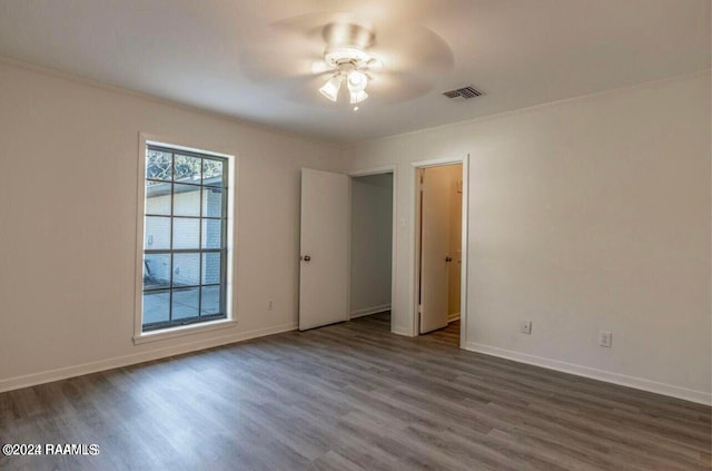 unfurnished room with dark wood-type flooring, ceiling fan, and ornamental molding