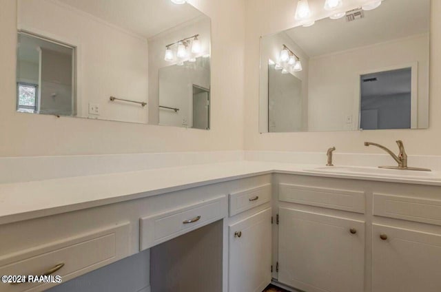 bathroom with ornamental molding and vanity