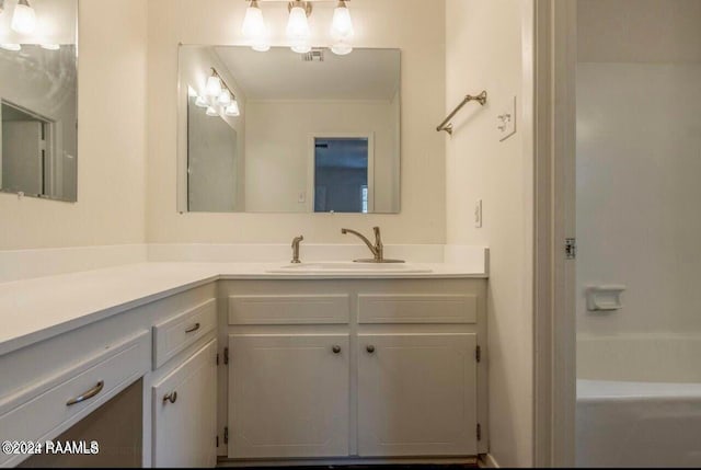 bathroom featuring vanity and a washtub