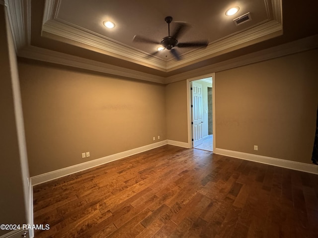 unfurnished room featuring crown molding, a raised ceiling, ceiling fan, and dark hardwood / wood-style flooring