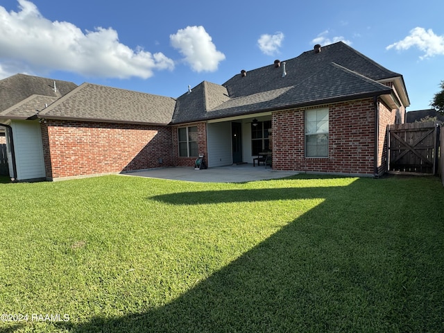 rear view of property featuring a patio area and a yard