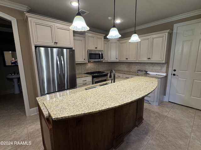 kitchen featuring decorative light fixtures, light stone countertops, appliances with stainless steel finishes, an island with sink, and decorative backsplash