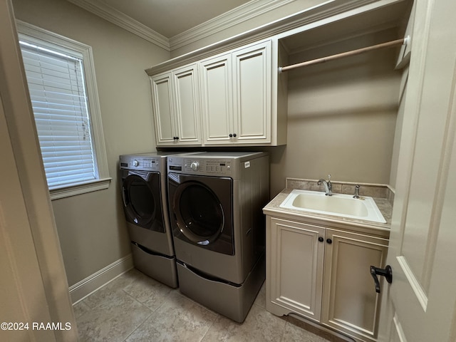 laundry room featuring ornamental molding, cabinets, washer and clothes dryer, and sink