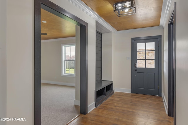 interior space with carpet floors, wooden ceiling, and ornamental molding