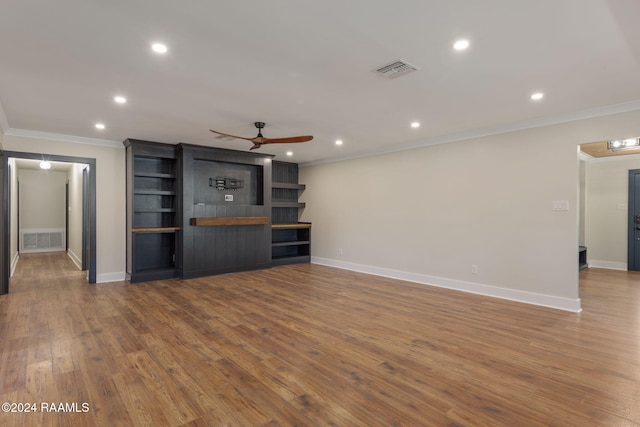 unfurnished living room featuring ceiling fan, hardwood / wood-style floors, and ornamental molding