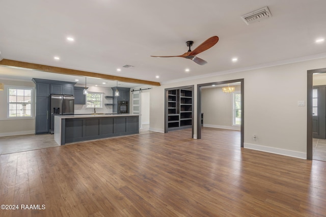 unfurnished living room with ornamental molding, ceiling fan, and dark wood-type flooring