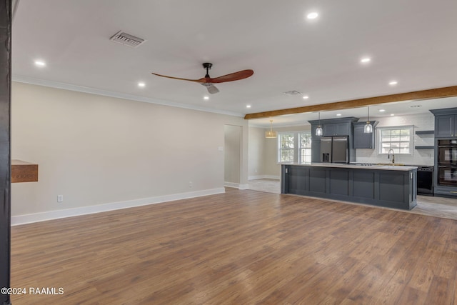 unfurnished living room featuring ceiling fan, sink, crown molding, and hardwood / wood-style flooring