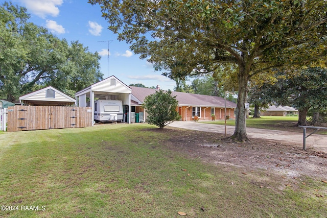 single story home featuring a front lawn, fence, driveway, and a carport