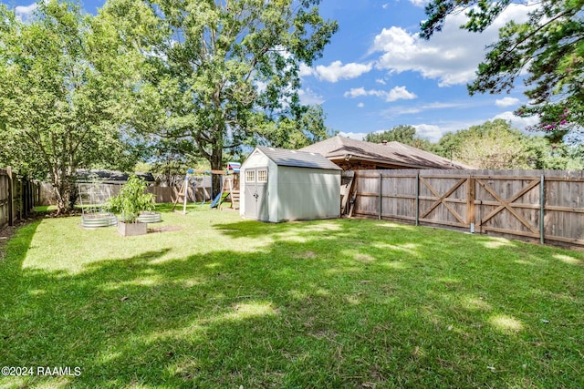 192 Tillou Andrus Dr, Opelousas, LA 70570 - view of yard featuring a fenced backyard, a playground, a shed, an outdoor structure, and a garden