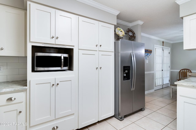 192 Tillou Andrus Dr, Opelousas, LA 70570 - kitchen with light countertops, ornamental molding, light tile patterned floors, stainless steel appliances, and white cabinetry