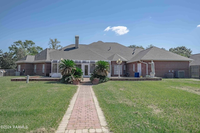 view of front of home with a front yard and central air condition unit