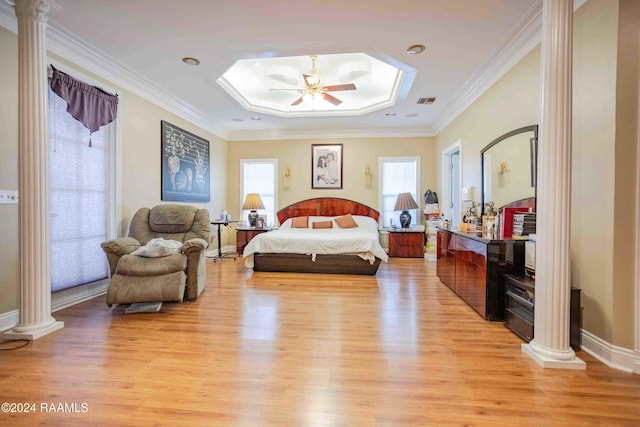 bedroom with decorative columns, crown molding, light hardwood / wood-style floors, and ceiling fan