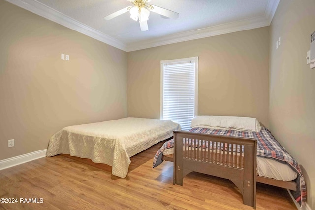 bedroom featuring wood-type flooring, ornamental molding, and ceiling fan