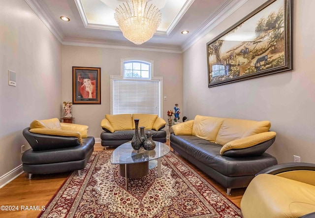 living room with a notable chandelier, light wood-type flooring, and ornamental molding