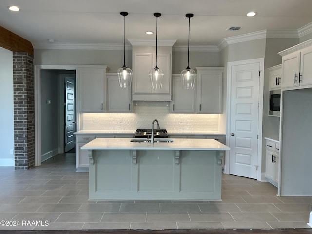 kitchen featuring white cabinetry, sink, an island with sink, pendant lighting, and light tile patterned flooring