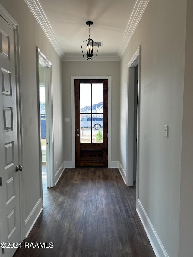 doorway to outside featuring dark hardwood / wood-style flooring, crown molding, and an inviting chandelier